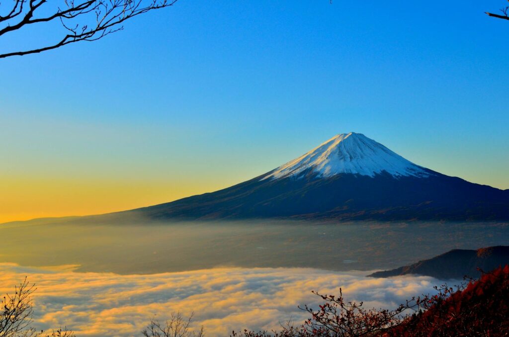 black and white mountain over yellow white and blue sky